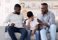 Family Support. Black father and grandfather comforting upset little boy at home