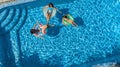 Family in swimming pool aerial drone view from above, happy mother and kids swim on inflatable ring donuts and have fun in water Royalty Free Stock Photo