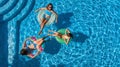 Family in swimming pool aerial drone view from above, happy mother and kids swim on inflatable ring donuts and have fun in water Royalty Free Stock Photo