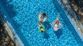 Family in swimming pool aerial drone view from above, happy mother and kids swim on inflatable ring donuts and have fun in water Royalty Free Stock Photo