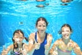 Family swims in pool under water, happy active mother and children have fun, fitness and sport