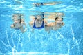 Family swims in pool under water, happy active mother and children have fun, fitness and sport with kids on vacation