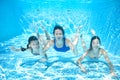 Family swims in pool underwater, happy active mother and children have fun under water, fitness and sport with kids