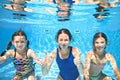 Family swims underwater in swimming pool, happy active mother and children have fun under water, fitness and sport with kids Royalty Free Stock Photo