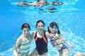 Family swims underwater in swimming pool, happy active mother and children have fun under water, fitness and sport with kids Royalty Free Stock Photo