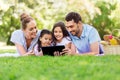 Family with tablet pc on picnic in summer park Royalty Free Stock Photo