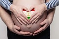 Family in Tajikistan concept. Man embracing pregnant woman belly and heart with Tajikistani flag colors closeup