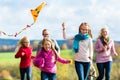 Family take walk in autumn forest flying kite Royalty Free Stock Photo