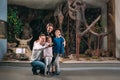 A family takes a selfie against a mammoth skeleton at the Museum of paleontology.