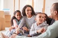 Family Taking A Break And Sitting On Sofa Celebrating Moving Into New Home Together Royalty Free Stock Photo