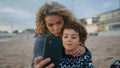 Family taking funny selfie on autumn beach closeup. Happy mother son enjoying Royalty Free Stock Photo