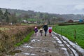 A family taking a walk along a road surrounded by farms and Welsh hills. Royalty Free Stock Photo