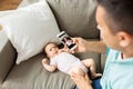 Father with smartphone taking picture baby at home Royalty Free Stock Photo