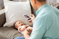 Father with smartphone taking picture baby at home Royalty Free Stock Photo