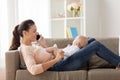 Mother with baby calling on smartphone at home