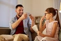 Father photographing daughter by cellphone at home