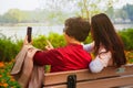 Family, technology and people concept - happy daughter and senior mother with smartphone sitting on park bench and taking Royalty Free Stock Photo