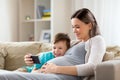 Pregnant mother and son with smartphone at home Royalty Free Stock Photo