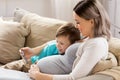 Pregnant mother and son with smartphone at home Royalty Free Stock Photo