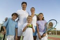Family on Tennis Court by net portrait front view