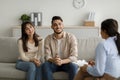 Family therapy. Happy middle eastern couple sitting on couch at counselor& x27;s office, listening advices and smiling Royalty Free Stock Photo