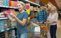 family of three adults are choosing yogurt in the dairy department store