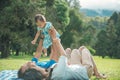 Family of three with baby girl happines laying on a grass