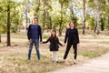 Family of three children on a walk in the park in the summer. brother and two sisters hold hands Royalty Free Stock Photo