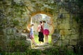Family of three exploring old caves dug into the tuff rock and used for human habitation in ancient times. Citta del Tufo