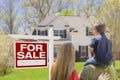 Family of Three Facing For Sale Real Estate Sign and House Royalty Free Stock Photo