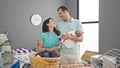 Family of three hanging clothes on clothesline at laundry room