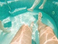 Family of three in hot tub, underwater shot of legs in bubbly pool water Royalty Free Stock Photo