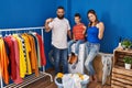 Family of three at laundry room pointing finger to one self smiling happy and proud