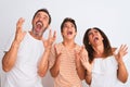 Family of three, mother, father and son standing over white isolated background crazy and mad shouting and yelling with aggressive Royalty Free Stock Photo