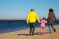 Family of three people walking along beach. Royalty Free Stock Photo