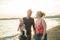 Family of three person is standing on sunset and sea backdrop Royalty Free Stock Photo