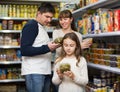 Family of three purchasing canned food Royalty Free Stock Photo