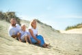 A family of three sit on the sand dunes near the town of Nida.Lithuania Royalty Free Stock Photo