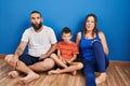 Family of three sitting on the floor at home making fish face with lips, crazy and comical gesture