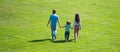 Family of three, spring banner. Back view of mother father and child son having fun outdoors at summer park. Royalty Free Stock Photo