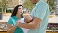 Family of three standing together at park