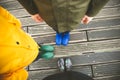 Family of three standing on woode pier in high rubber boots