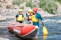 Family of three wearing life vests and helmets going to row an inflatable catamaran