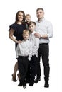 A family with three young children. Mom, dad, two sons and a daughter. Full height. Family relationships. love and tenderness. Royalty Free Stock Photo