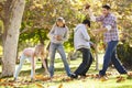 Family Throwing Autumn Leaves In The Air