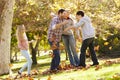 Family Throwing Autumn Leaves In The Air