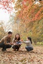 Family throwing leaves in the park in the autumn