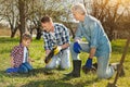 Family of three generations planting the tree in the garden Royalty Free Stock Photo