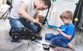 Family time: dad and son little boy repairing a model radio-controlled car at home. Royalty Free Stock Photo