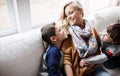 Family time on the home front. two adorable little boys bonding with their mother on the sofa at home. Royalty Free Stock Photo